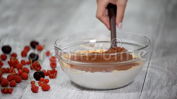 糖果师把铲子和大量的鸡蛋糖面粉和可可粉混合在一起做成巧克力饼干蛋糕视频的预览图