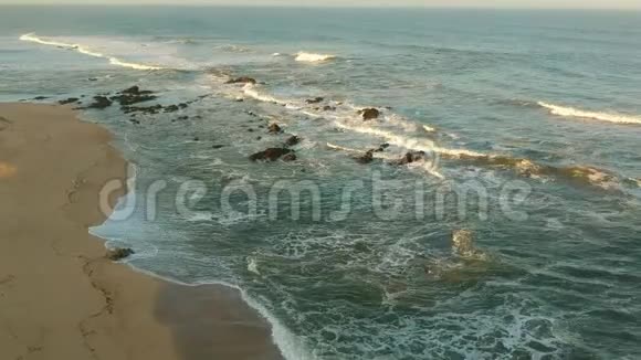 日出时在葡萄牙的波沃阿德瓦尔齐姆海滩上空向前飞行的空中射击视频的预览图