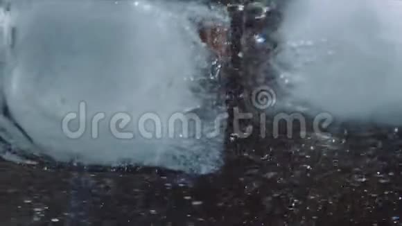 一个冰块掉进一杯水中的宏镜头视频的预览图