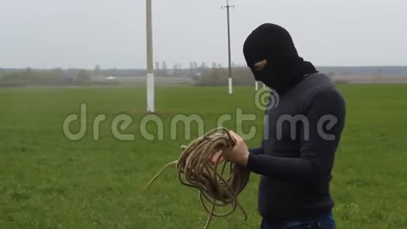 一个戴着黑色面具带着绳子的人试图偷高压电线视频的预览图