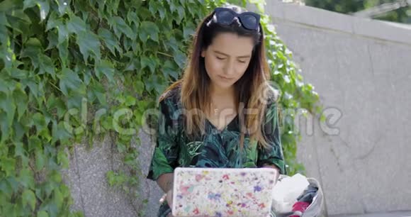 一位年轻女子一边工作一边打手机视频的预览图