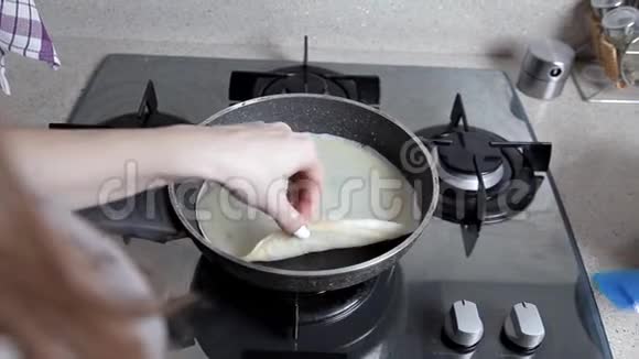 女人准备薄煎饼把面团倒在热煎锅上圣诞假期视频的预览图