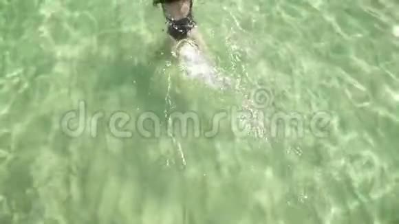 女孩在清澈多彩的透明水中游泳视频的预览图