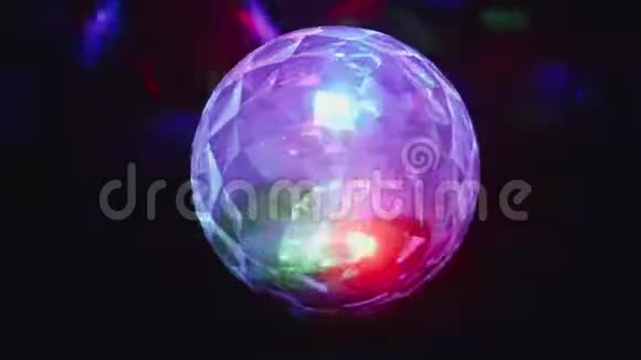 一个发光的彩色迪斯科球花环在黑暗中旋转视频的预览图