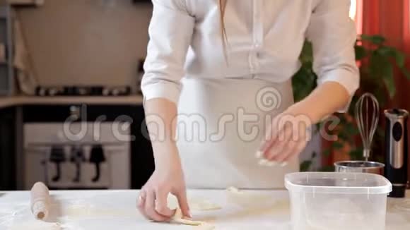 穿围裙的女孩把生面团的残骸放在一个塑料容器里视频的预览图