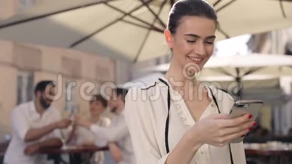 街头酒吧的快乐女人用手机视频的预览图