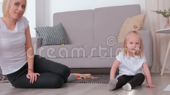 小可爱的金发女孩和她迷人的妈妈坐在沙发附近玩气球视频的预览图