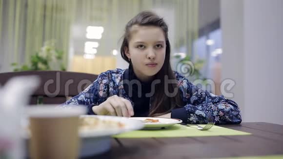 在咖啡馆吃披萨的女孩一个在披萨店的少年正在吃晚饭视频的预览图
