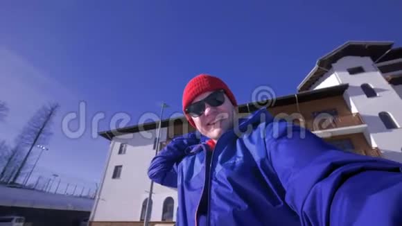 一个年轻人看着镜头头上戴着一支长矛喜欢冬天的雪山穿着蓝色滑雪板视频的预览图