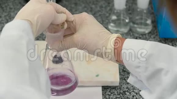 科学家在烧瓶中混合粉红色液体视频的预览图