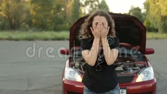 街上一个伤心的女人在她破碎的汽车前视频的预览图