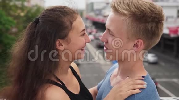 在城市的夏日里年轻快乐的恋爱女孩轻轻地拥抱她的男朋友视频的预览图