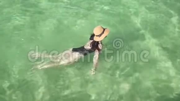 女孩在清澈多彩的透明水中游泳视频的预览图
