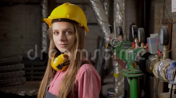 年轻可爱的女孩建筑工人站在管道附近微笑着看着镜头建筑构思视频的预览图