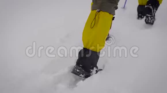 两个人去探险专业的徒步旅行靴子和裤腿有助于在雪地里移动视频的预览图