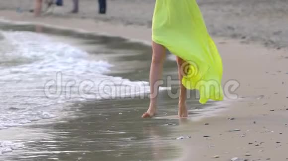 穿黄长裙的少女美腿赤脚沙滩跑近风浪视频的预览图
