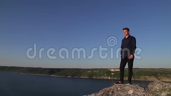 年轻英俊的男子站在陆地的边缘望着远方视频的预览图