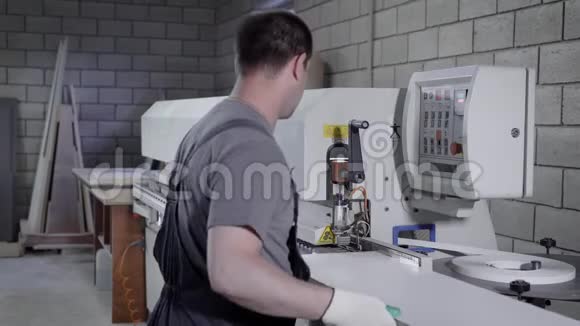 木匠在工厂的一台现代化的边缘捆扎机上工作视频的预览图