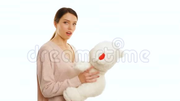 女孩惊讶于白色泰迪熊与红色碎片孤立视频的预览图