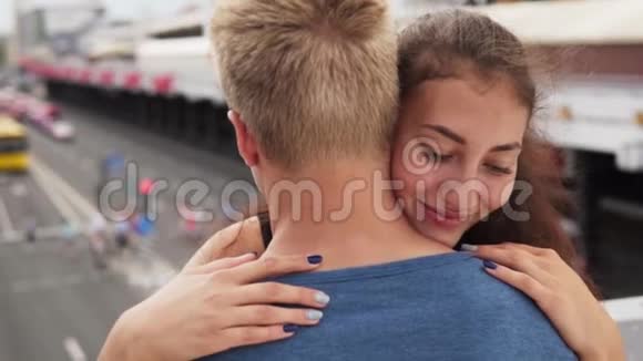 年轻快乐的被迷住的女孩在城市大街轻轻地拥抱她的男朋友视频的预览图