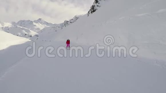 女子滑雪者在冬季的斜坡上滑下山滑雪和推棍视频的预览图