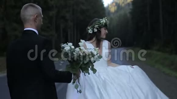 在路上结婚的情侣新郎带着一束鲜花去见新娘视频的预览图