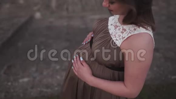 紧紧抱着肚子年轻的孕妇在她的旅行目的地国家拉脱维亚可以俯瞰城市视频的预览图