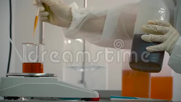 用移液管将液体从瓶子中加入电子天平上的瓶子视频的预览图