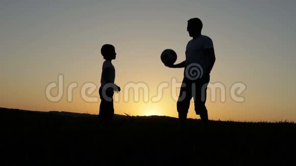 日落时分父子俩在公园里踢足球视频的预览图
