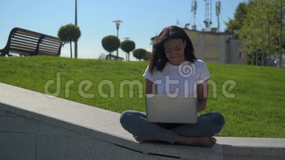 一位正在公园工作的年轻女士双腿交叉视频的预览图