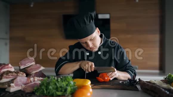 厨师穿着黑色的衣服戴着帽子切番茄视频的预览图