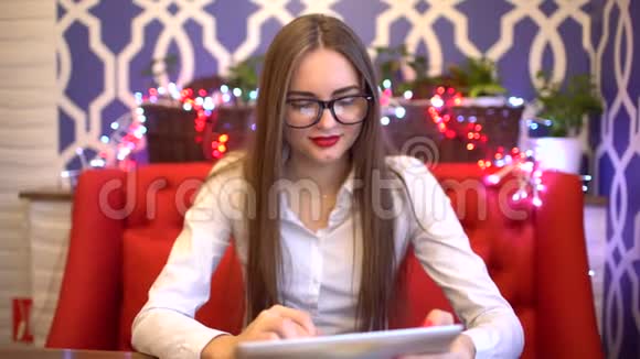 年轻的女商人坐在咖啡馆里工作一台平板电脑4千克视频的预览图