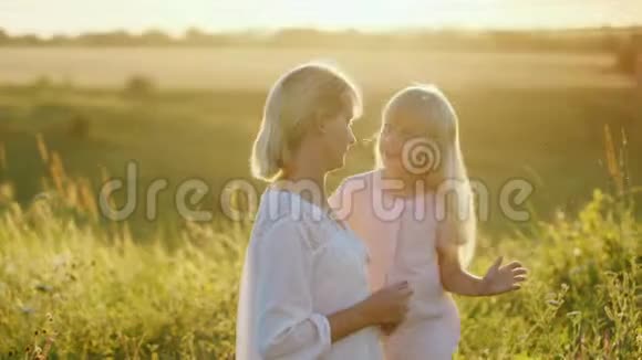 酷女孩把妈妈的头发绿色草地上视频的预览图
