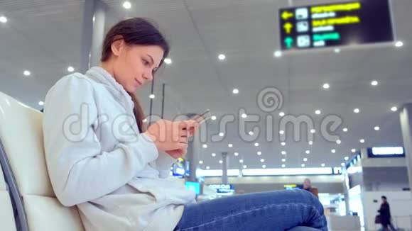 女士在机场大厅手机上在线登记侧视视频的预览图