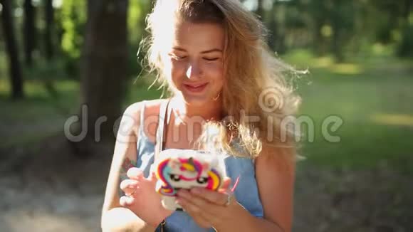 穿着漂亮的欧洲女人在日落时分在森林里用手机自拍和发短信在户外自拍视频的预览图