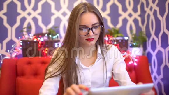 女学生穿着白色上衣使用信用卡进行网上购物4k女性使用平板电脑进行在线视频的预览图