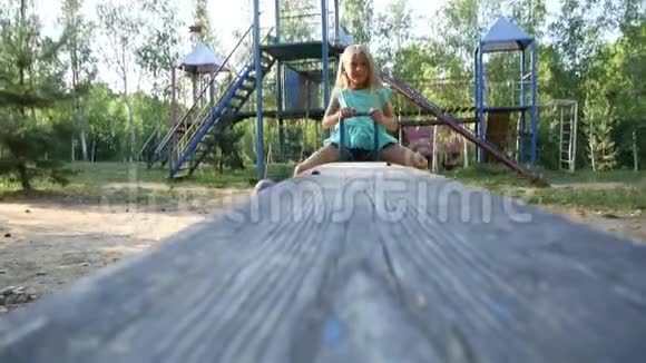 夏天坐跷跷板的女孩慢动作视频的预览图