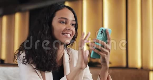 年轻快乐的商务女性在咖啡馆里使用智能手机应用程序在手机上发短信漂亮的休闲女性视频的预览图