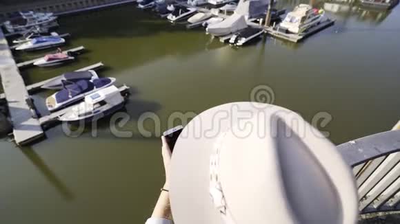匿名妇女在河堤上使用智能手机视频的预览图