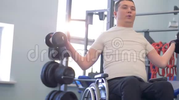 一名有两个哑铃的残疾男子在健身房的训练课程视频的预览图
