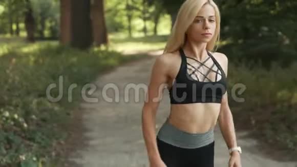 年轻女子在公园慢跑前热身视频的预览图