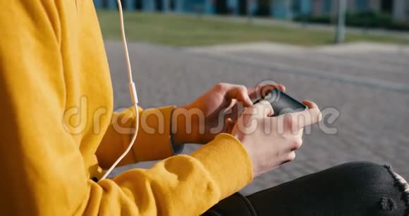 无名男手穿着黄色毛衣正在玩发短信在手机上浏览4K录像没有脸视频的预览图
