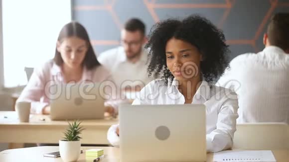 在工作场所用笔记本电脑和电话聊天的黑人女人视频的预览图