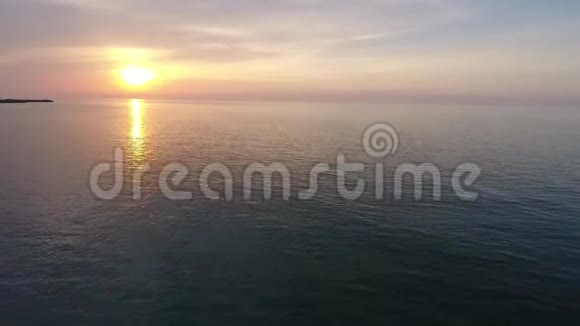 在海滩拍摄一个美丽的夏日日落海上日落无人机镜头视频的预览图