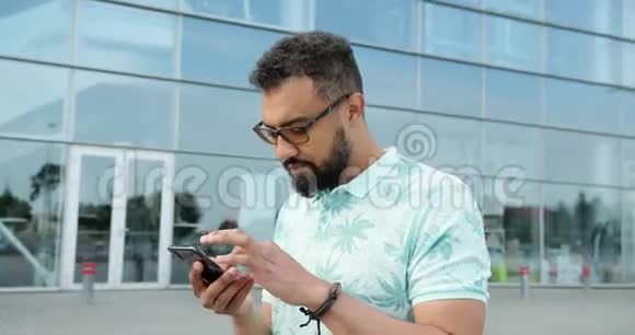 旋转观看英俊的非洲男子戴着眼镜在手机附近聊天和浏览视频的预览图