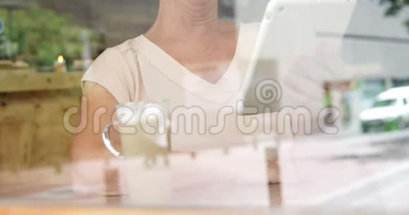 4k咖啡厅使用数码平板电脑的高级女性视频的预览图