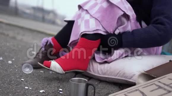无家可归的女人喜欢穿在户外厚厚的红色袜子上的鞋子视频的预览图