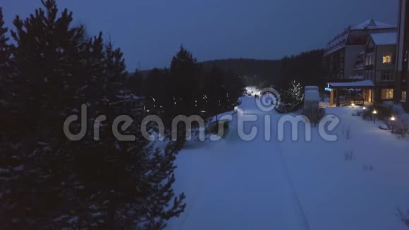 冬天傍晚的度假之路剪辑冬季傍晚有花环的度假村无灯光公园小路的俯视图视频的预览图