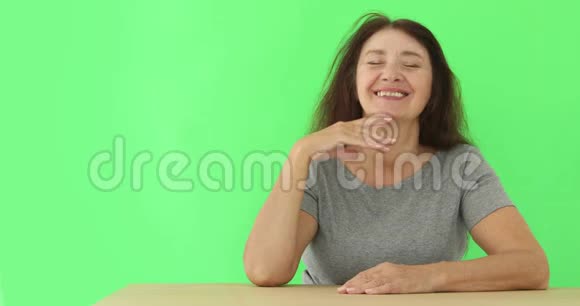 坐在桌子上笑着的老妇人视频的预览图