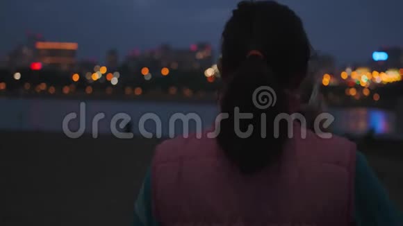女孩戴上耳机开始在夜城慢跑视频的预览图